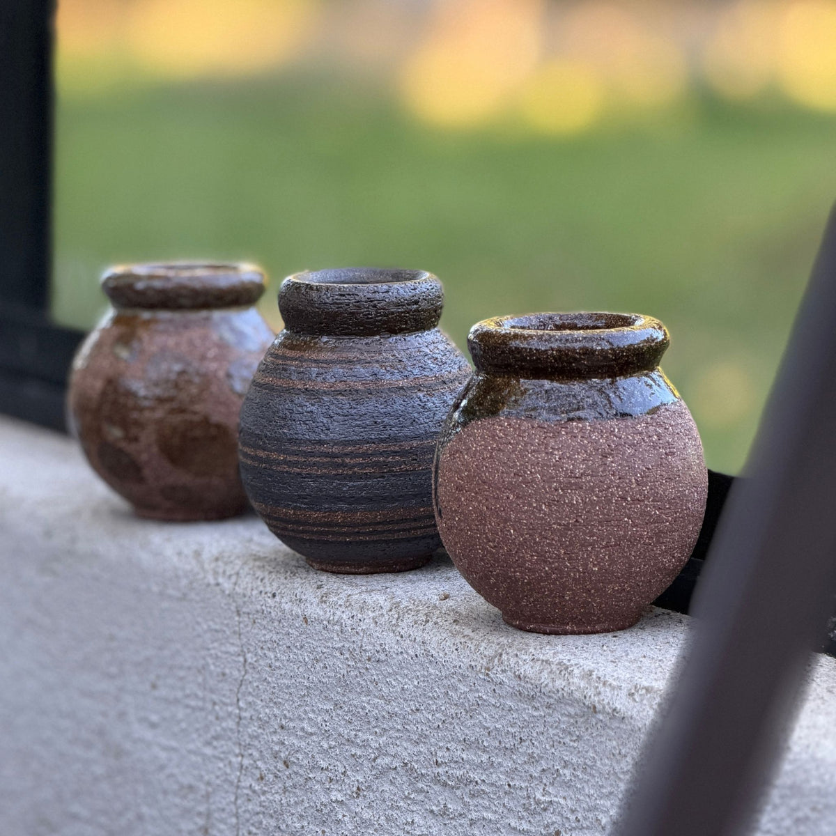 Tre små Terra keramikvaser med olika dekorer och glasyrer, handgjorda av Paradisverkstaden på Öland