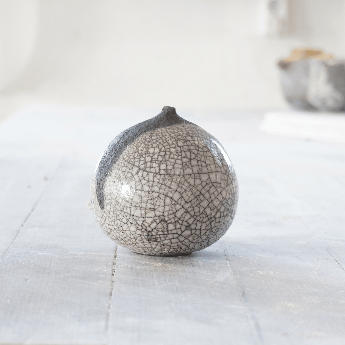 Raku-skulptur av Eva Paradis i grå och svart glasyr med krackeleringar och mjukt organisk form, handgjord på Öland.