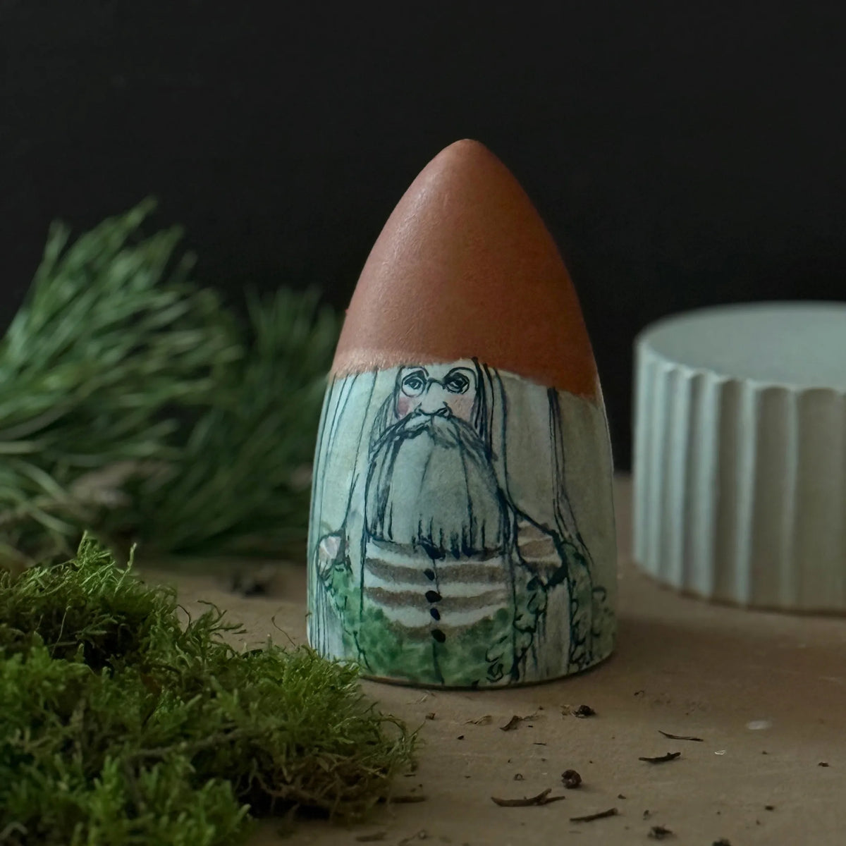 Tomte i keramik med brun luva och skägg